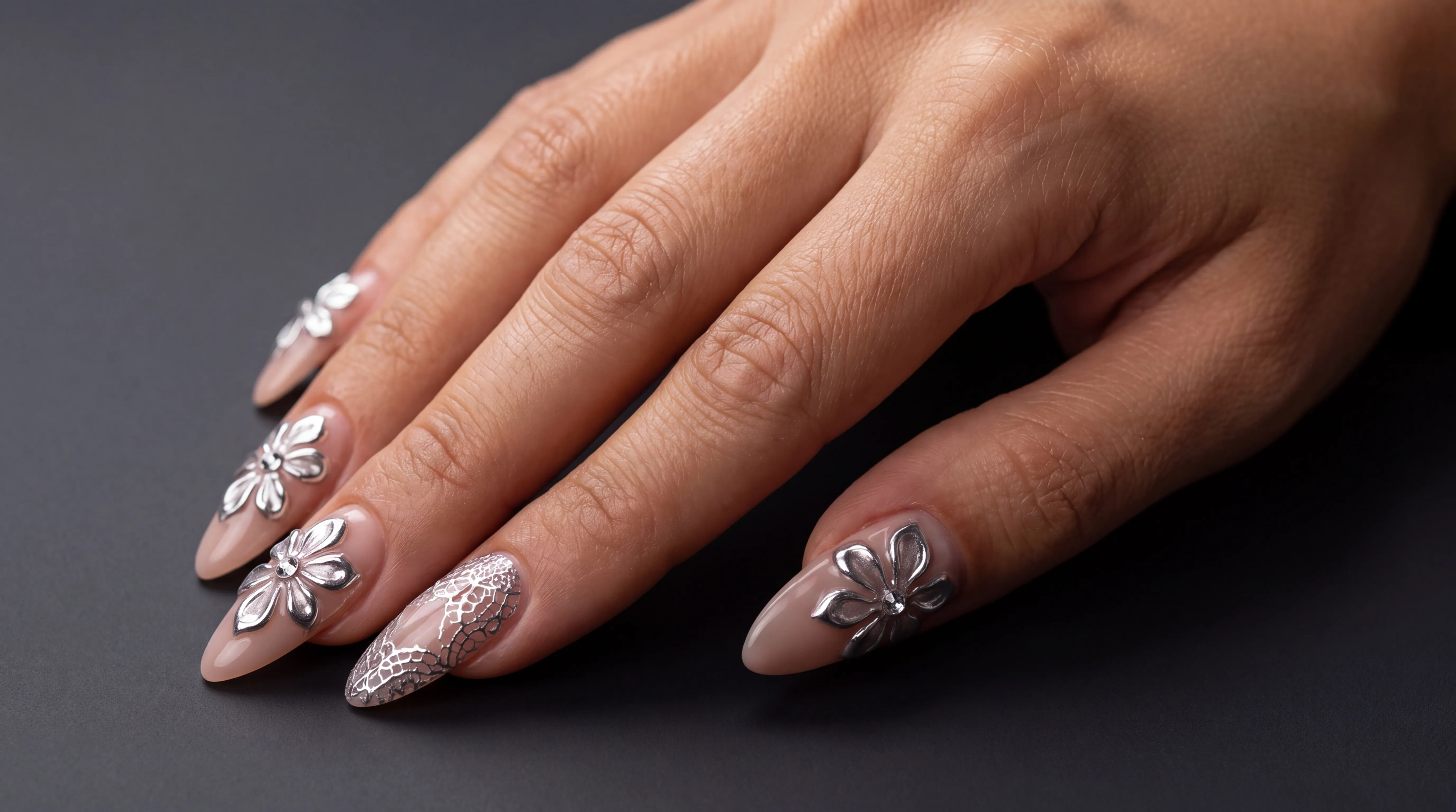 Almond nails with sculpted chrome florals and crystals
